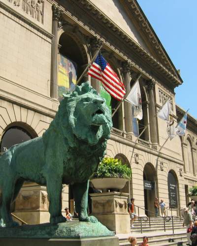 A lion statue outside a big museum
