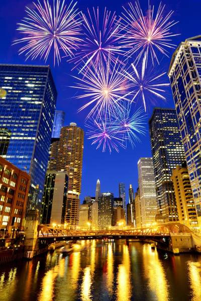 A view down the chicago river towards fireworks over downtown for new years celebrations