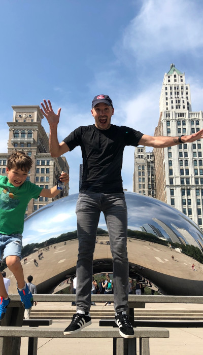 Father and son jumping in front of the Bean 