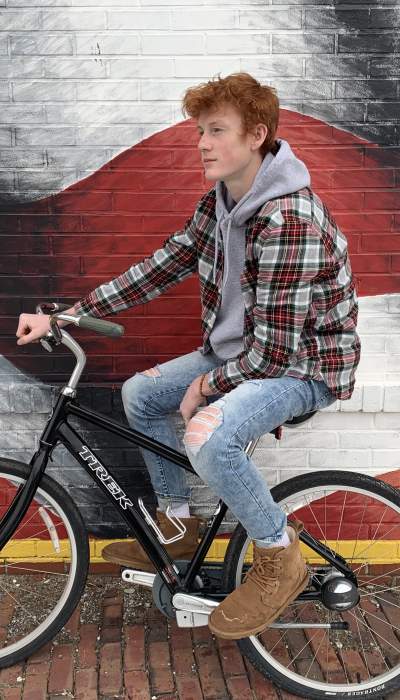 Biker in front of a mural.