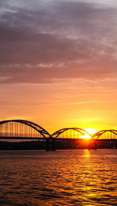 Sunset over river with bridge