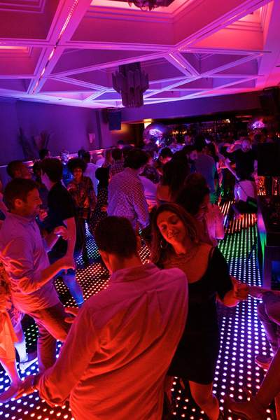 Patrons dancing on a lit up dance floor