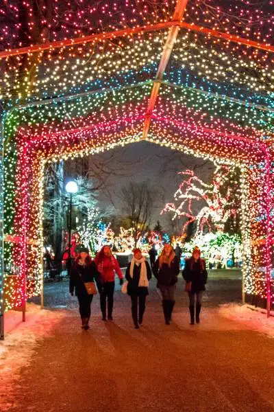 People walking under a display of lights