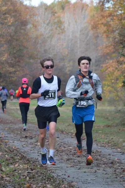 Runners race on an outdoor track in fall