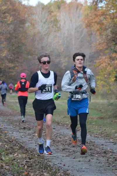 Runners race on an outdoor track in fall