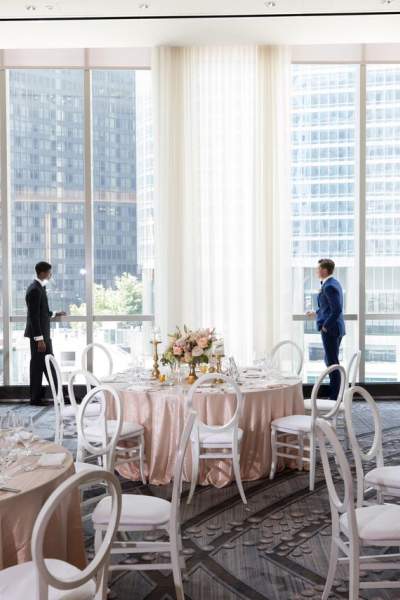 Two men in dinning room styled for a wedding