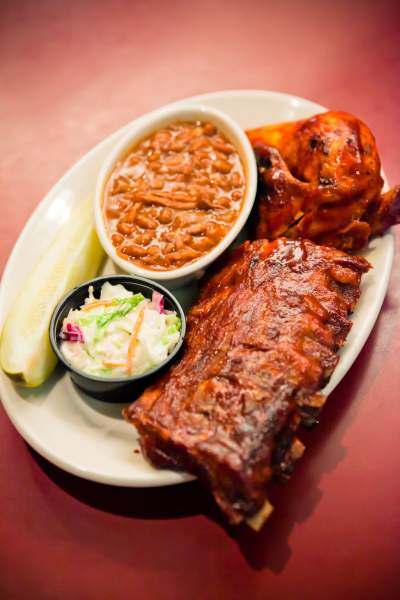 A plate of bbq food including ribs, slaw and beans