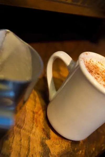 A coffee mug filled to the top with a pumpkin spiced latte