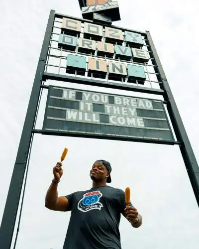 A man stands in front of a sign