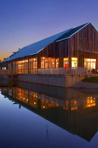 A photo of the Firefly grill during sunset with the lake reflecting the building.