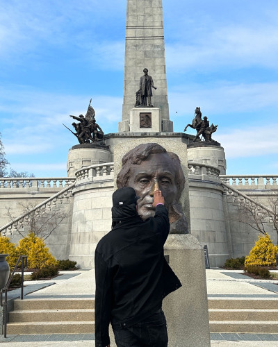 Sherman "Dilla" Thomas rubs the brass bust of Abraham Lincoln at his tomb in Springfield