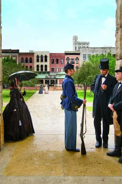 People dressed in older clothing standing around