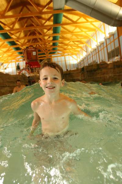 Boy smiling while in a wave pool.