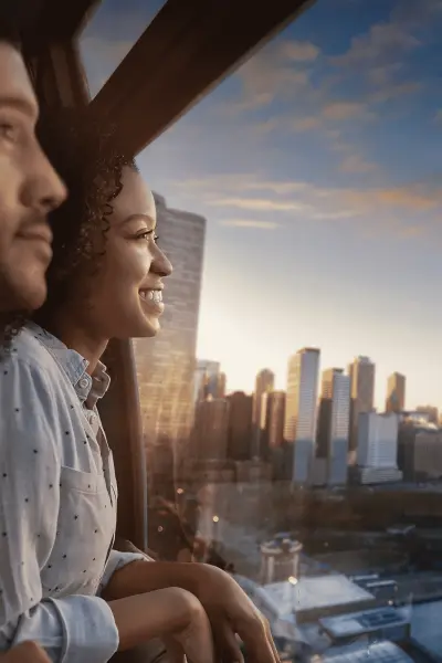 Couple inside the Centennial Wheel during sunset overlooking the city.