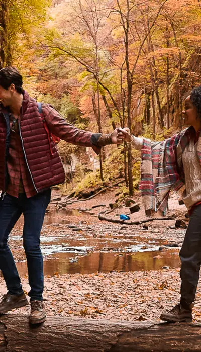 Couple hiking through the woods during fall.