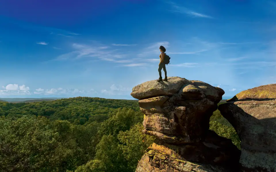 Hiker on the Garden of the Gods Camel Rock looking over the forest.