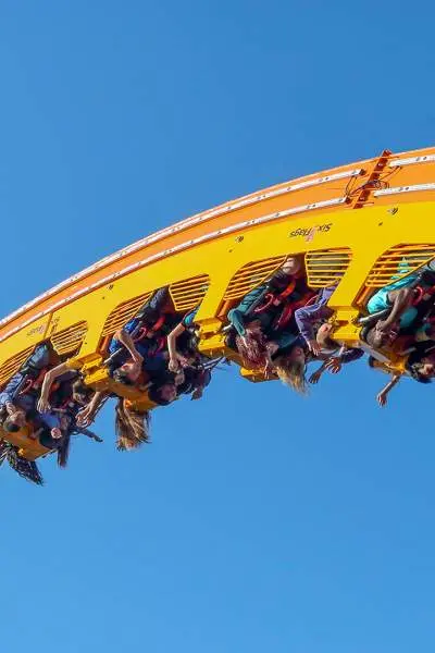 Group of people riding the roller coaster in mid air. 