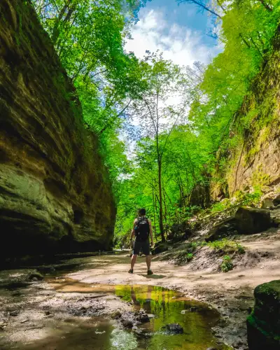 A man stands between two rockfaces 