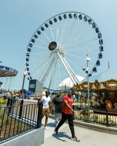 Visitors walk through Navy Pier with the Centennial Wheel in the background