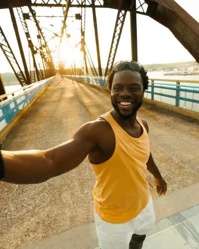 A man takes a selfie at sunset on the Old Chain of Rocks Bridge