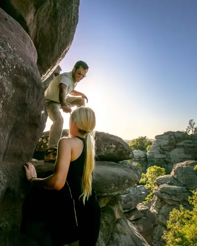 Two people climbing up big rocks in Shawnee National Forest