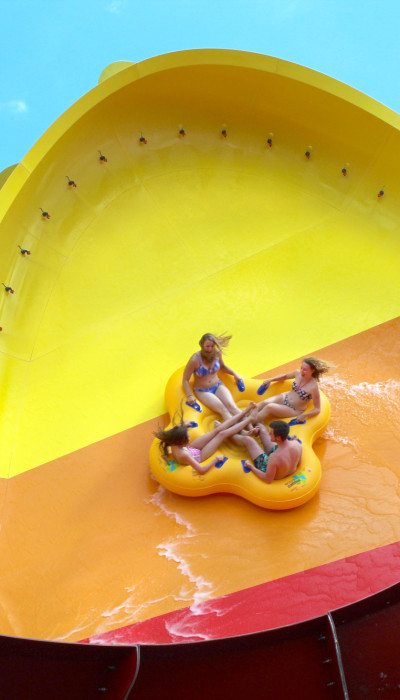 Group of friends on an inflatable floaty at Raging Waves.
