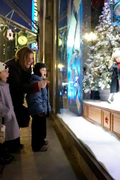 Woman and kids looking outside in to window display