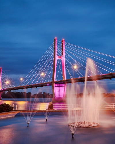 A lit up bridge with water fountains