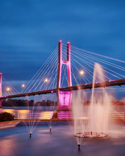 A lit up bridge with water fountains