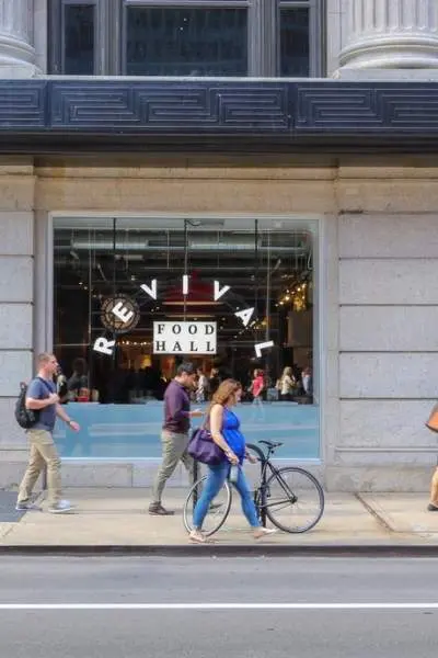 People walking sidewalk along building