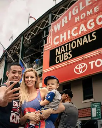 A family taking a photo in front of the Wrigley Field Stadium