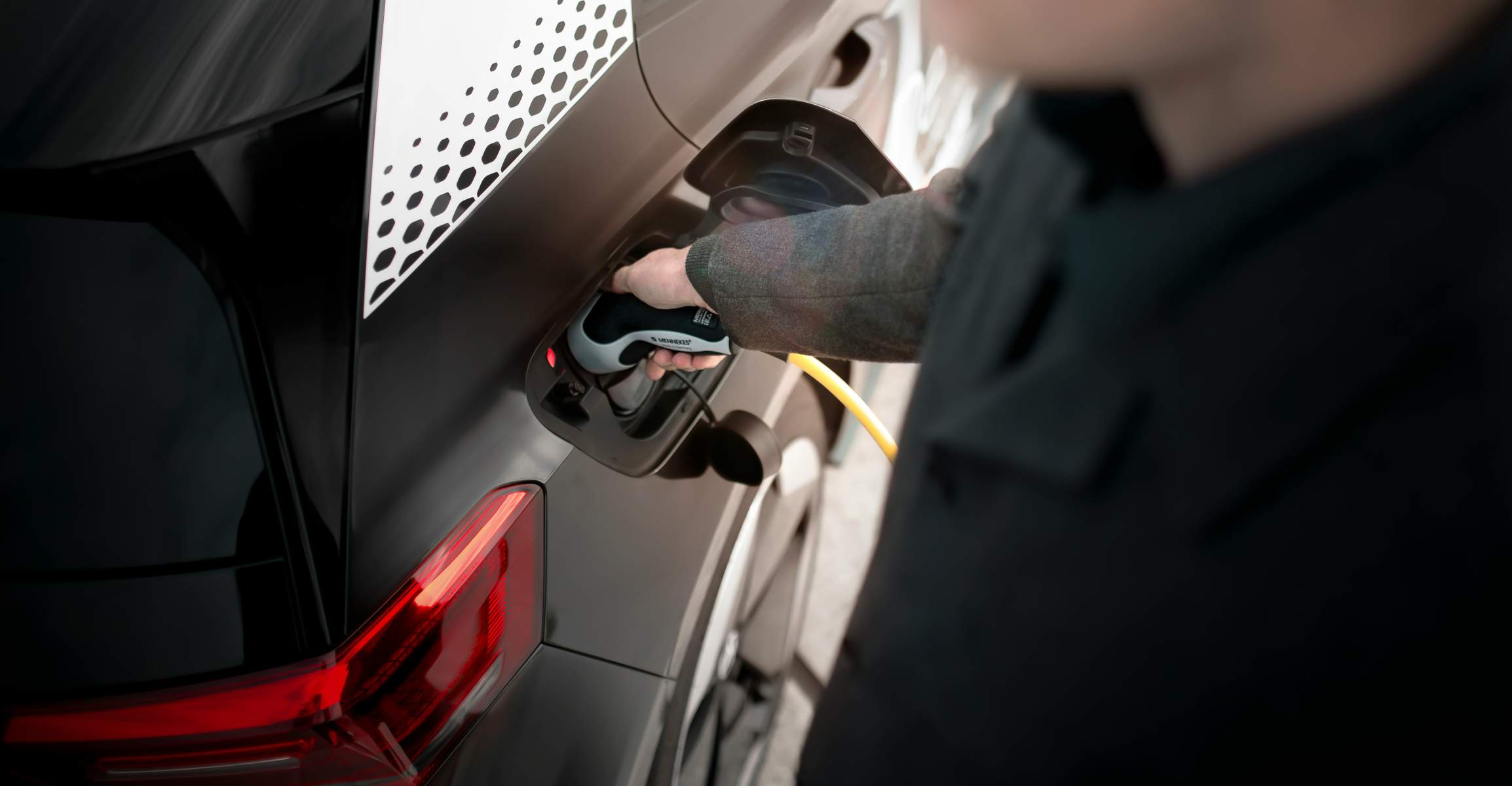 A man charges an electric vehicle